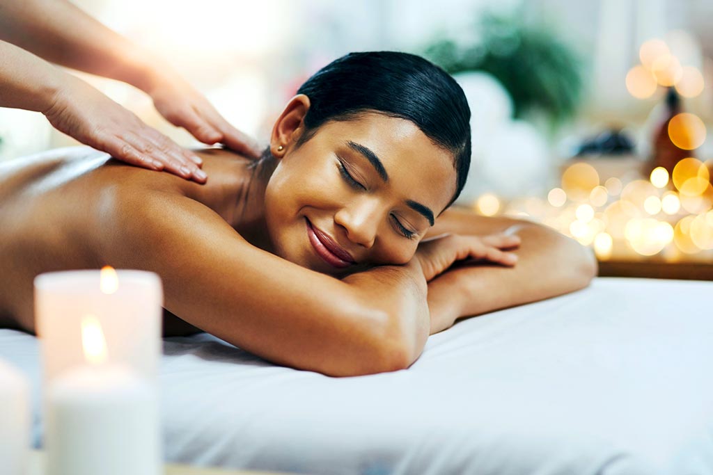 Shot of a relaxed an cheerful young woman getting a massage indoors at a spa.