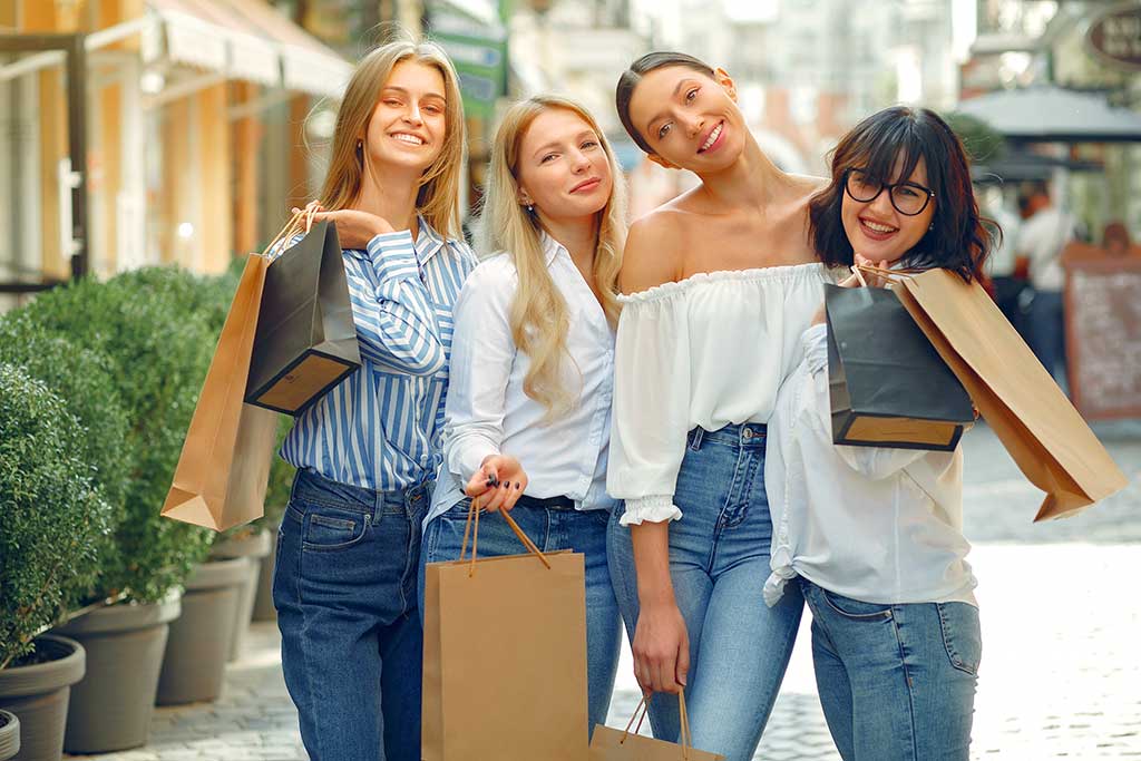 Beautiful girls in a summer city. Ladies with shopping bags
