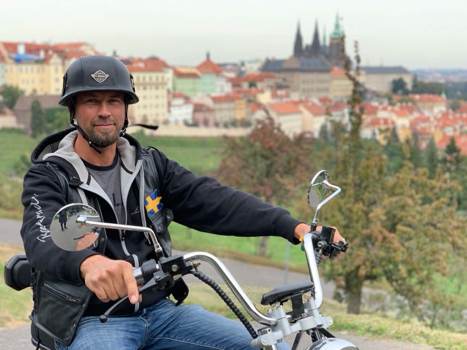 Adventure Trike Fahrer auf einem elektrischen 3-Rad-Roller mit der Prager Burg im Hintergrund